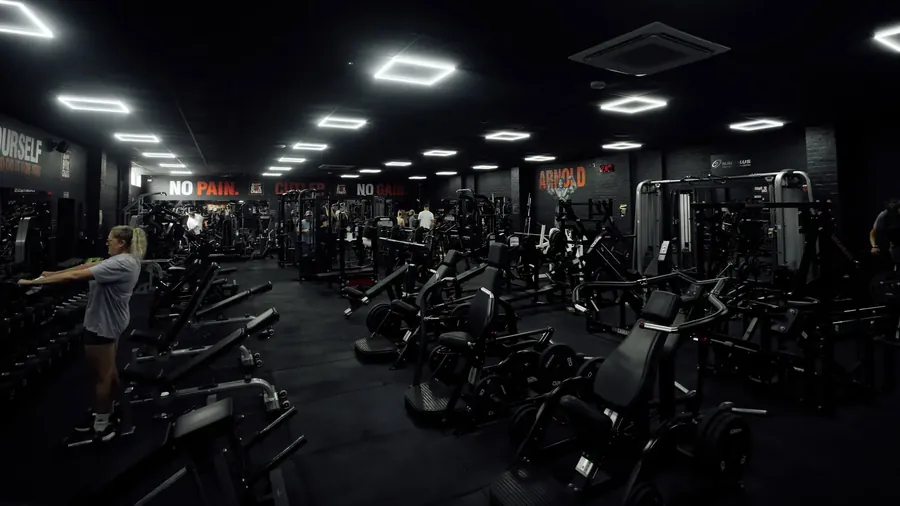 A member choosing dumbbells from the rack on the main gym floor at BoxCross UK, Wisbech