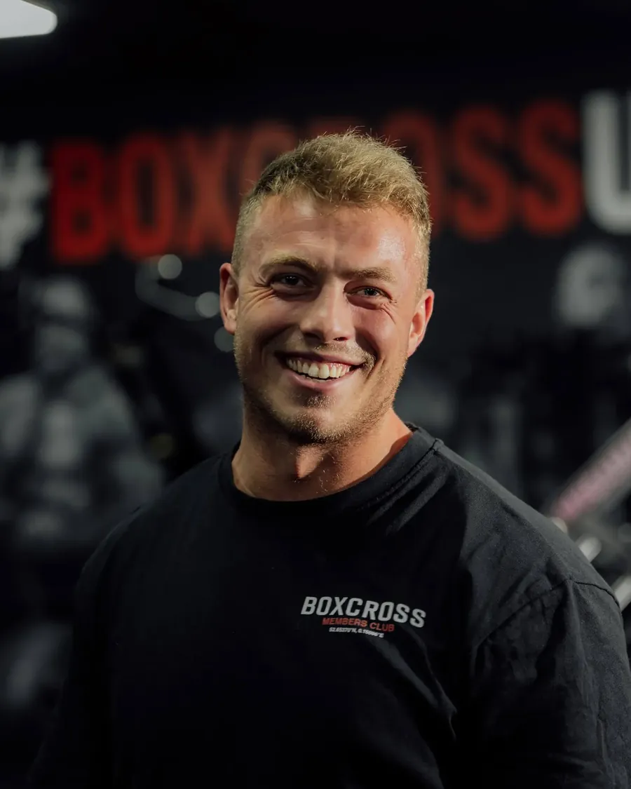 Daniel Higgs, personal trainer in Wisbech, laughing in front of the BoxCross UK mural