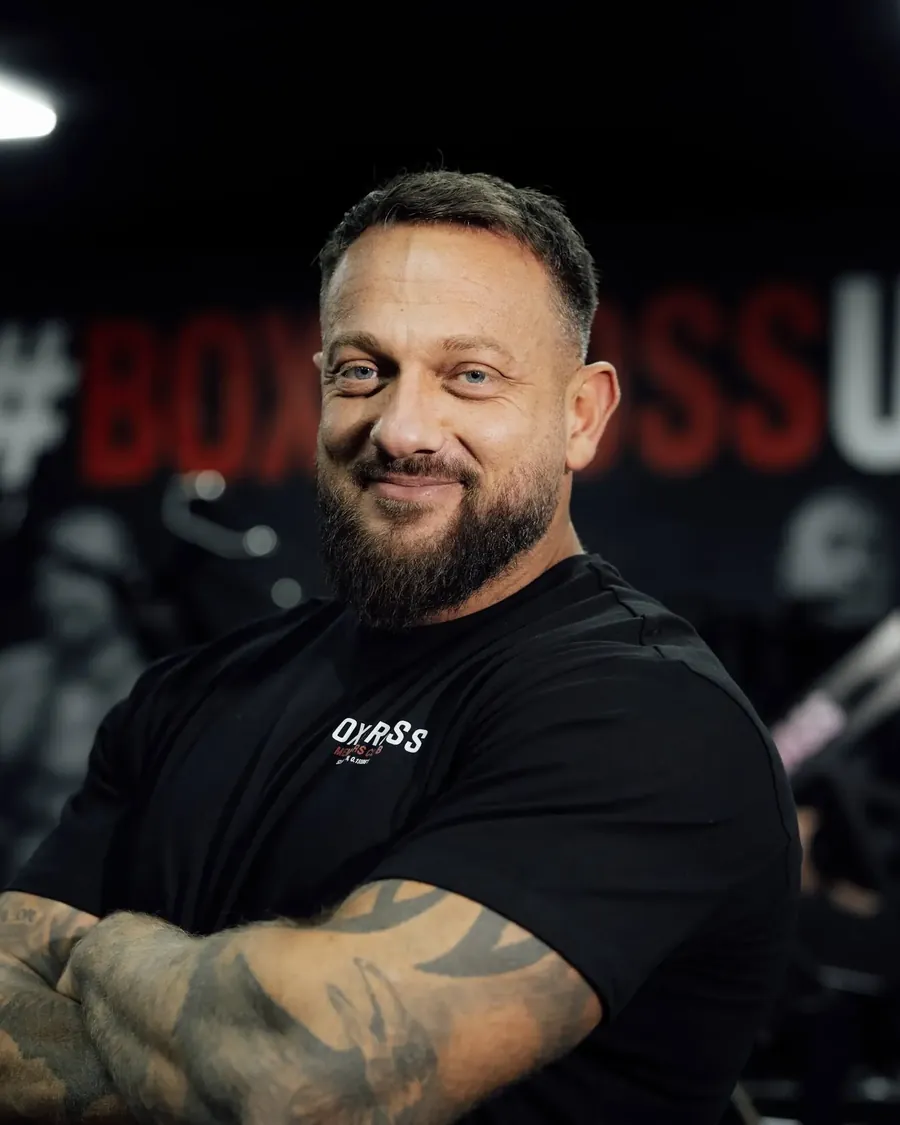 Dave Carse, personal trainer in Wisbech, arms folded in front of the BoxCross UK mural