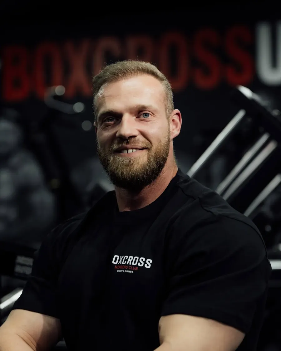 Jack Earle, body transformation coach in Wisbech, seated in front of the BoxCross UK mural
